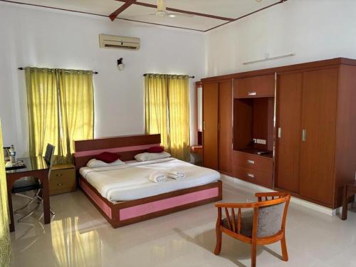 een slaapkamer met een bed, een bureau en een tafel bij The Boho Cochin in Cochin
