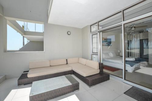 un soggiorno con un divano e una camera da letto di Spacious Beach Access Apartment at Dolphin Beach a Bloubergstrand