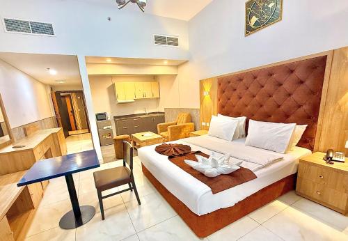 a hotel room with a large bed and a desk at New Dream Plaza Hotel Apartment in Dubai