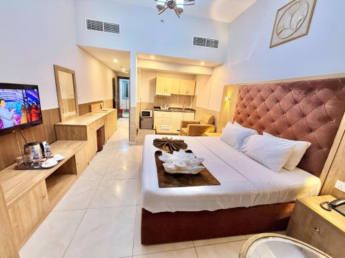 a hotel room with a bed and a television at New Dream Plaza Hotel Apartment in Dubai