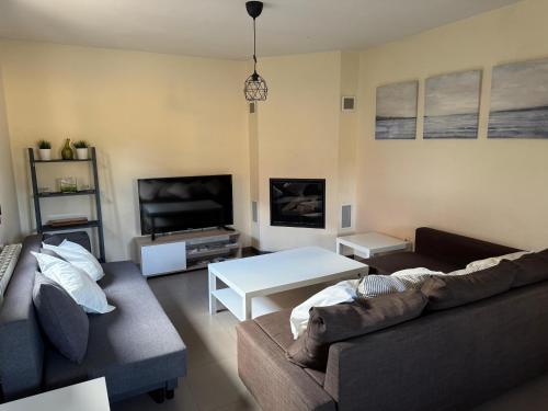 a living room with two couches and a tv at Mirador de Peña La Estrella in Ortigosa del Monte