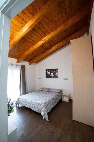 a bedroom with a bed and a wooden ceiling at Dicentra Guest House in Villanova dʼAsti