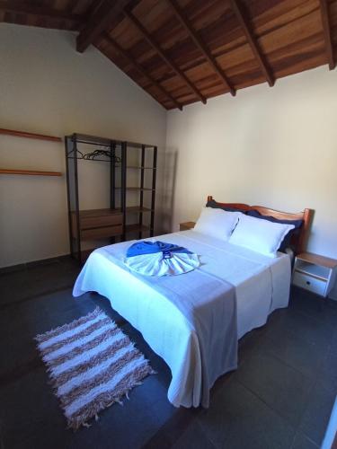 a bedroom with a large bed with a blue blanket at Chalé da Lili in Nova Friburgo