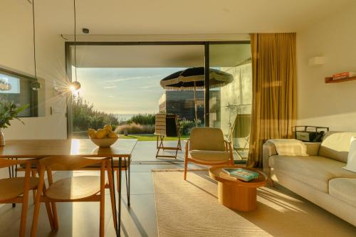 a living room with a couch and a table at oceanHUTS Coxos Adults Only in Ericeira