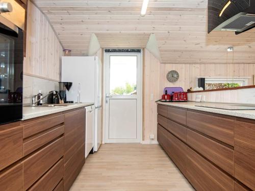 una cocina con armarios de madera y una puerta en 8 person holiday home in Hejls-By Traum, en Hejls