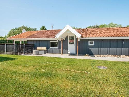 una casa azul con un patio de hierba delante de ella en 8 person holiday home in Hejls-By Traum, en Hejls