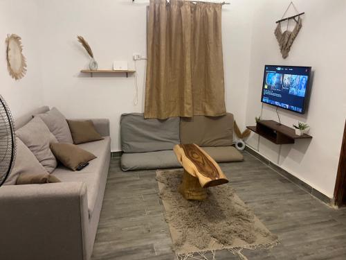 a living room with a couch and a tv at Ge boho house in Dahab