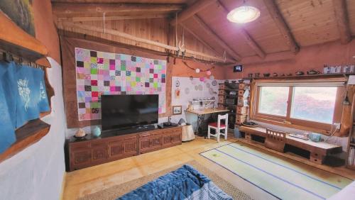 a living room with a flat screen tv and a table at 숲속 작은 황토집 