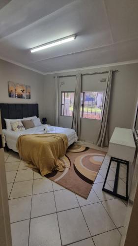 a bedroom with a large bed and a table at Nestville apartments in Solwezi