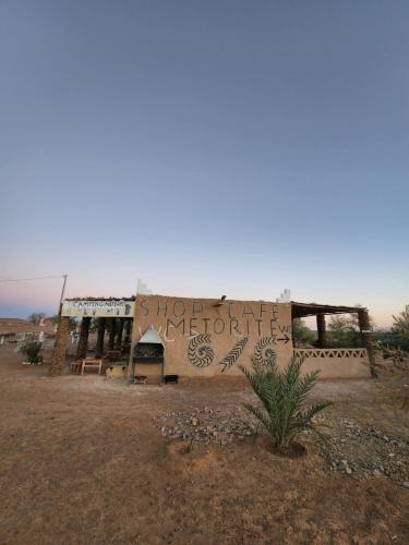 a building in the middle of a desert at Camping Meteorite in Merzane