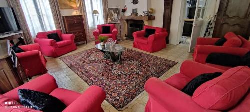 a living room with red chairs and a table at Maison spacieuse avec jardin à Cabourg, 250 m² in Cabourg