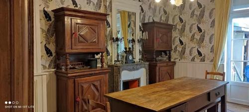 a kitchen with wooden cabinets and a fireplace in it at Maison spacieuse avec jardin à Cabourg, 250 m² in Cabourg