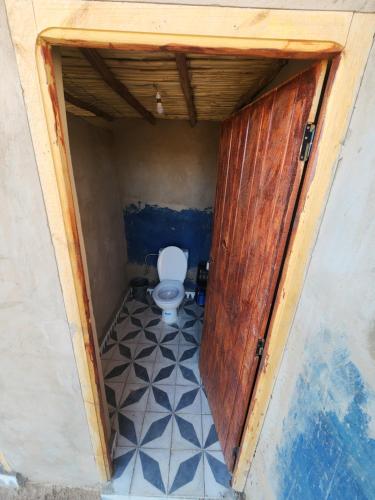 a small bathroom with a toilet in a doorway at Camping Meteorite in Merzane