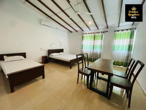 a room with two beds and a table and chairs at Golden Kingdom Hotel in Kandy