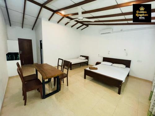 a bedroom with a table and a bed and a table and chairs at Golden Kingdom Hotel in Kandy