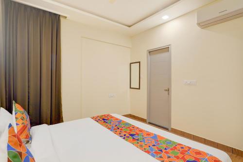 Habitación de hotel con cama y puerta en FabHotel East Land, en Bangalore