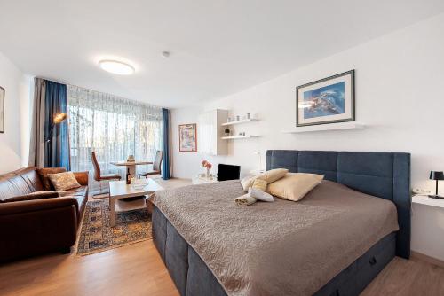 a bedroom with a large bed and a living room at Fewo Jutta in Oberuhldingen