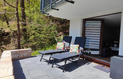 zwei Stühle und ein Tisch auf einer Terrasse in der Unterkunft Chalet am Diemelsee - Ferienwohnung mit Terrasse im Sauerland in Heringhausen