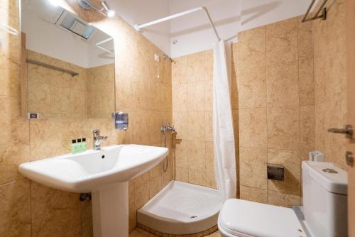 a bathroom with a sink and a shower and a toilet at Ulrika in Aegina Town