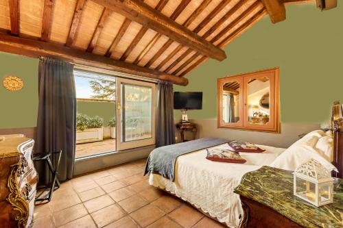 a bedroom with a bed and a large window at I Capricci Di Merion - Resort & Spa in Tuoro sul Trasimeno