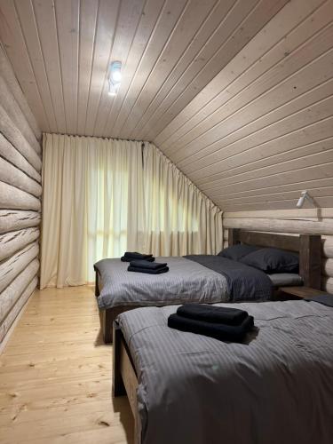 a bedroom with three beds in a wooden room at Zrub House Карпати in Rozhanka Nizhnyaya