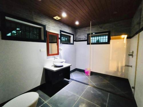 een badkamer met een toilet, een wastafel en een spiegel bij The Boho Cochin in Cochin