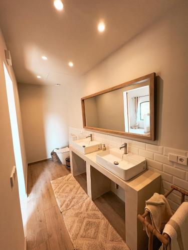 a bathroom with two sinks and a large mirror at Mimosa Lodge in Girona