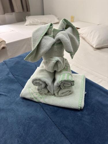 a pile of towels sitting on top of a bed at Alzira Plaza Hotel in São Lourenço