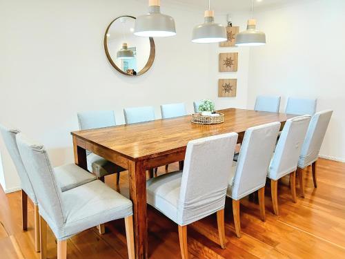a dining room table with chairs and a mirror at Shell Cove,Game Room, 3 Baths, King Bed, 7kW EV Point, Spacious 1-Story Home in Dunmore