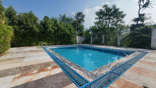 a swimming pool in a backyard with a rattan swimming poolvisor at Dreamland Resort in Nainital