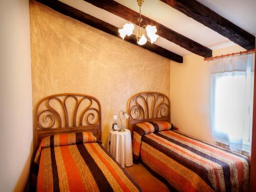 a bedroom with two beds and a window at Casa rural zaragoza in Almonacid de la Sierra