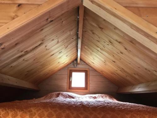 ein Zimmer mit einem Dach mit einem Bett darin in der Unterkunft Cabane Au bois du Haut Folin in Saint-Prix