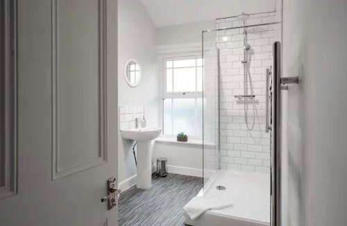 a white bathroom with a sink and a shower at Ribby Stays - 2 bed Cottage Pet Friendly in Wrea Green