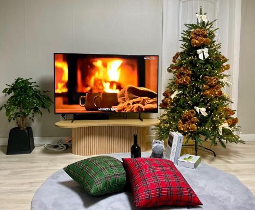 a living room with a christmas tree and a tv at Indeogwon Hue Stay in Anyang