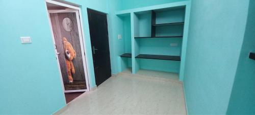 a room with blue walls and a hallway with shelves at Miracle Stay in Madurai