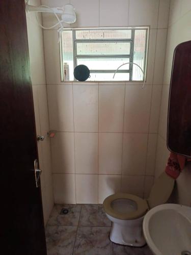 a small bathroom with a toilet and a window at Sitio Pé da Serra São Pedro in São Pedro