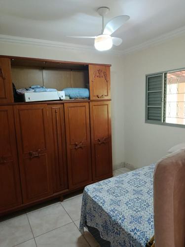 a bedroom with a bed and wooden cabinets and a ceiling at Sitio Pé da Serra São Pedro in São Pedro