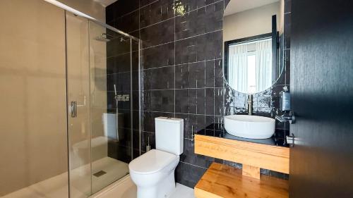 a bathroom with a toilet and a sink and a shower at GuestReady - Gaveto de Lisboa GuestHouse in Ponta Delgada