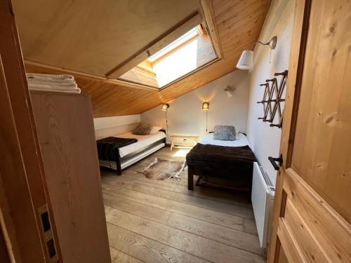 a small room with two beds and a window at Appartement du Petit Bois in Megève