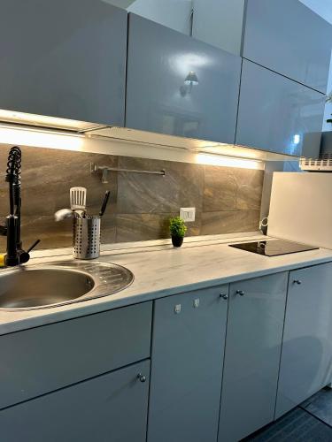 een keuken met witte kasten en een spoelbak bij Affori- Apartment Milan in Milaan