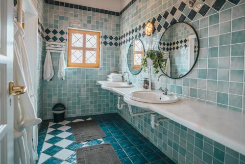 een blauw betegelde badkamer met 2 wastafels en spiegels bij Ocean House Swakopmund in Swakopmund