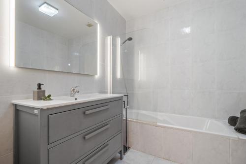 a bathroom with a sink and a tub and a mirror at Sunny Ponta "Nomads' village" in Ponta do Sol