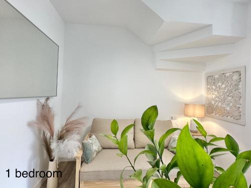 a living room with a couch and a plant at Boutique Higueron Spa in Fuengirola