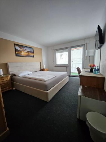 ein Schlafzimmer mit einem großen Bett und einem Fenster in der Unterkunft Gästehaus Schröder in Groß-Gerau