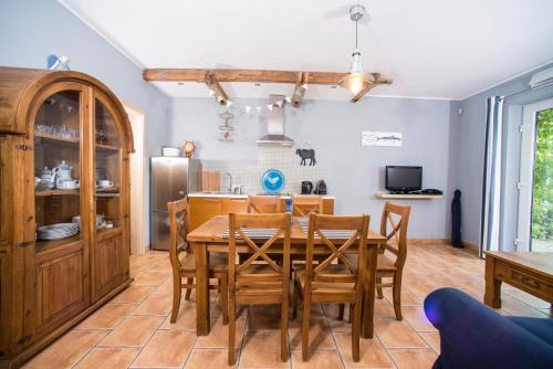 a kitchen and dining room with a table and chairs at Villa Mare Apartamenty in Grzybowo