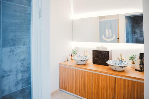 two bowls on top of a wooden counter with a microwave at Mulan Stay 松尾大社 in Kyoto