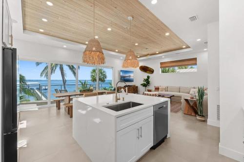 a kitchen with a sink and a living room at One Palm in South Cocoa Beach