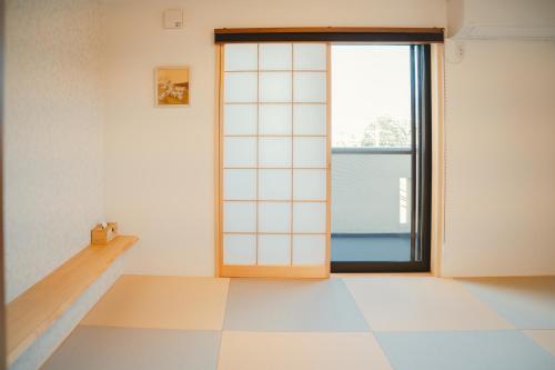a room with a door and a tiled floor at Mulan Stay 松尾大社 in Kyoto