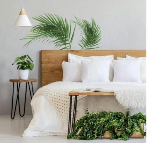 a bedroom with a bed with white pillows and plants at Soulful healing academy in Point Cook
