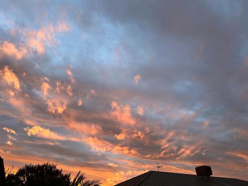 a cloudy sky at sunset with a roof at Soulful healing academy in Point Cook